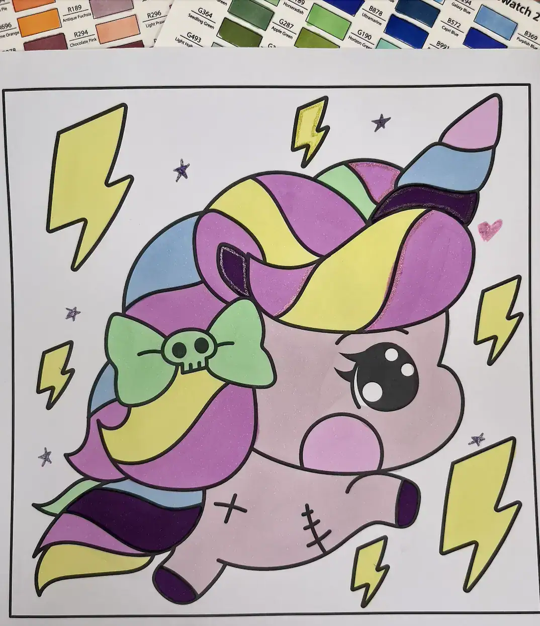 Pastel goth unicorn with rainbow hair and skull bow colored in soft blended tones.